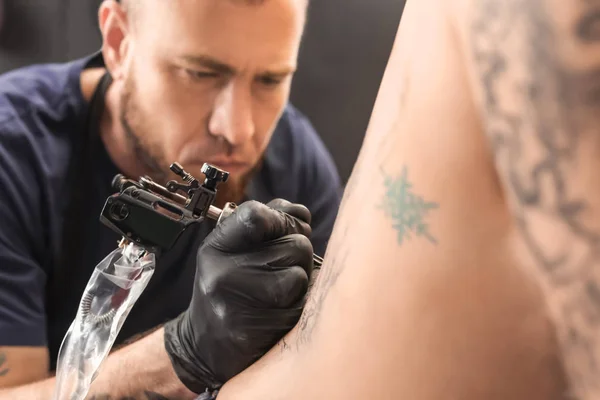 Professional artist making tattoo in salon — Stock Photo, Image