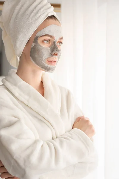 Junge Frau mit Tonmaske zu Hause — Stockfoto