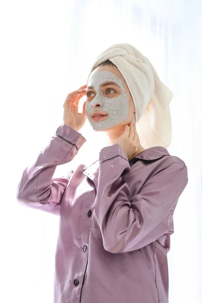 Young woman with facial mask at home — Stock Photo, Image