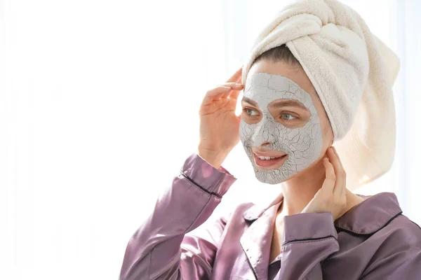 Jonge vrouw met gezichtsmasker thuis — Stockfoto