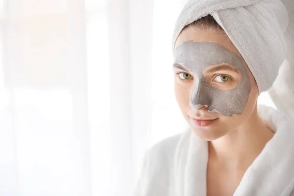 Giovane donna con maschera di argilla a casa — Foto Stock