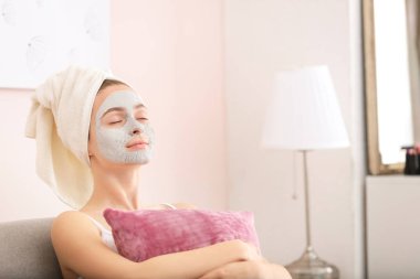 Evde kilden maskeli genç bir kadın var.