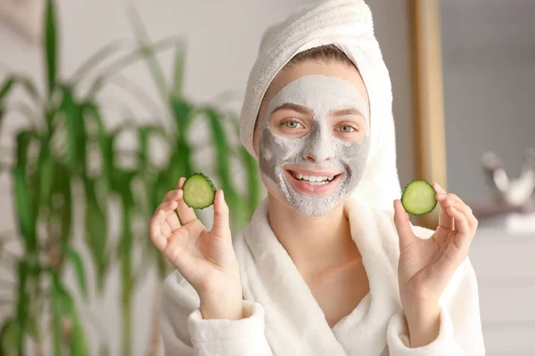 Young woman with clay mask and cucumber slices at home — 스톡 사진