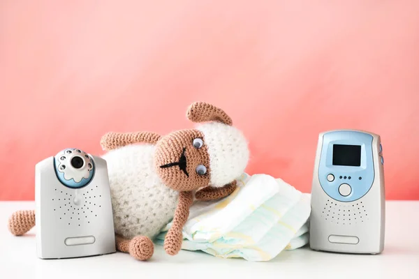 Monitor de bebê moderno, brinquedo e fraldas na mesa — Fotografia de Stock
