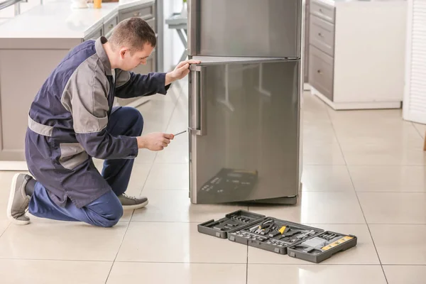 Mężczyzna technika naprawy lodówki w kuchni — Zdjęcie stockowe
