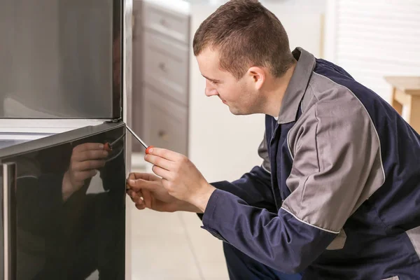 Mężczyzna technika naprawy lodówki w kuchni — Zdjęcie stockowe