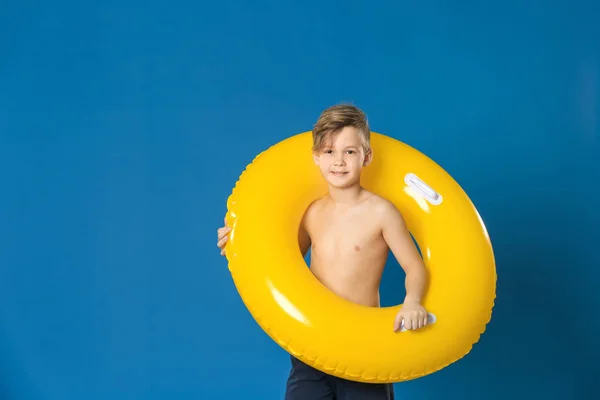 Cute little boy z nadmuchiwanym pierścieniem na tle koloru — Zdjęcie stockowe