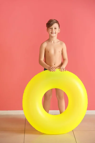 Cute little boy with inflatable ring near color wall — Stock Photo, Image