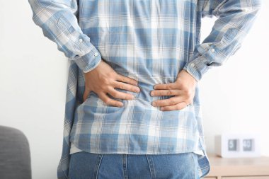 Genç adam sırt ağrısı evde, closeup acı