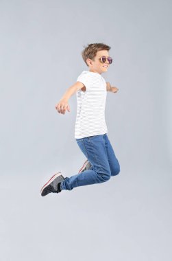 Gri arka planda kot pantolon jumping çocuk