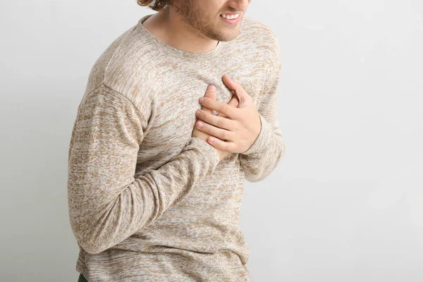 흰색 바탕에 가슴 통증에서 고통 하는 젊은 남자 — 스톡 사진