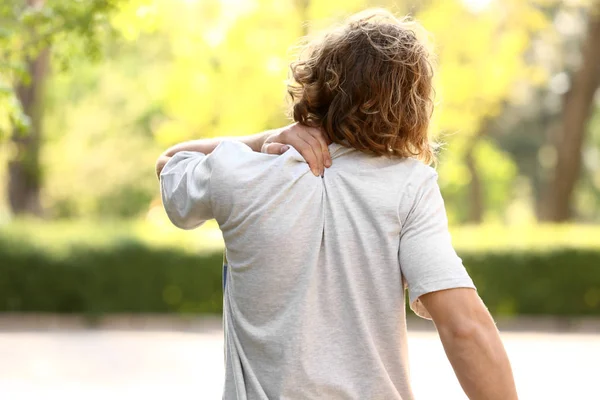 Giovane uomo che soffre di dolore al collo all'aperto — Foto Stock