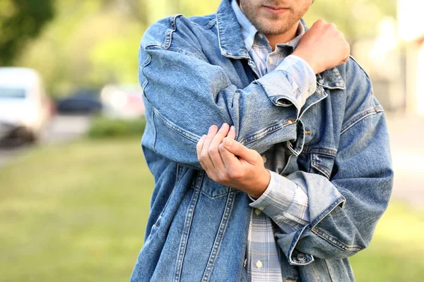 Jonge man die lijdt aan pijn in de elleboog buitenshuis — Stockfoto