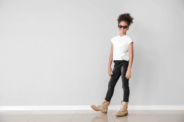 Snygg afro-amerikansk flicka i jeans nära ljus vägg — Stockfoto