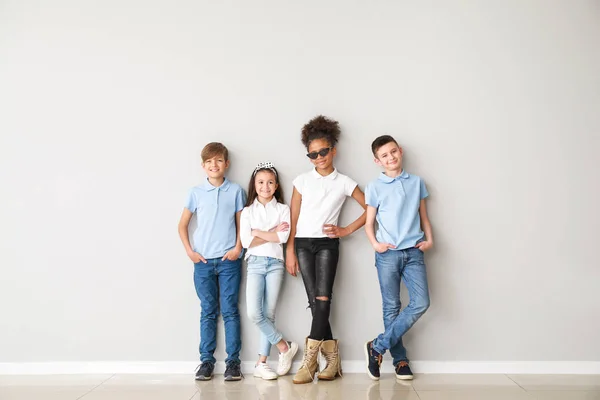 Bambini alla moda in jeans vicino a parete leggera — Foto Stock