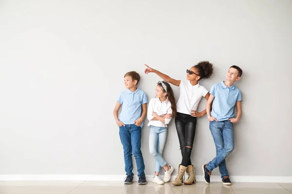 Niños con estilo en jeans cerca de la pared de luz — Foto de Stock