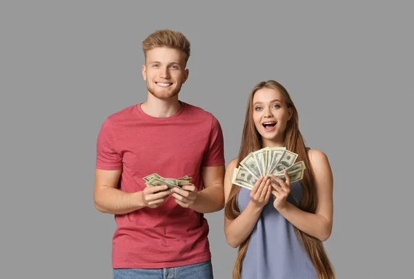 Щаслива пара з грошима на сірому фоні — стокове фото