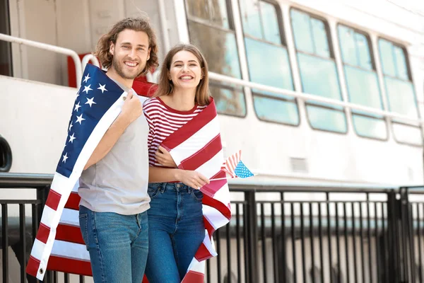 Boldog fiatal pár amerikai zászló a töltésen. Függetlenség napja ünneplése — Stock Fotó