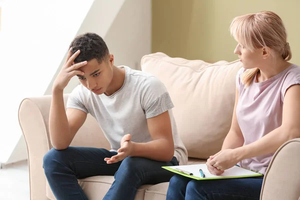 Female psychologist working with depressed teenage boy in office — Stock Photo, Image