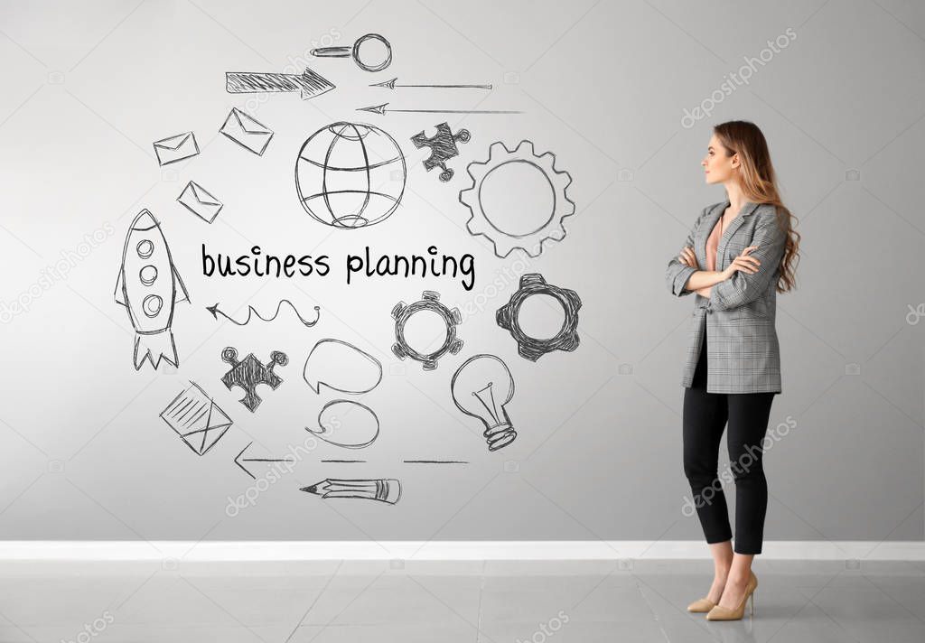 Woman in formal clothes near light wall with drawings. Concept of business plan development