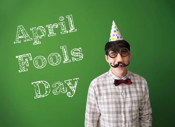 Funny Asian man with party decor for April Fools' Day celebration on color background — Stock Photo, Image