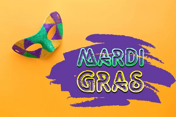 Máscara festiva con texto MARDI GRAS (también conocido como Martes Gordo) sobre fondo de color —  Fotos de Stock