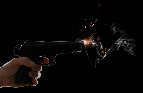 Mannelijke hand met schiet pistool op donkere achtergrond — Stockfoto