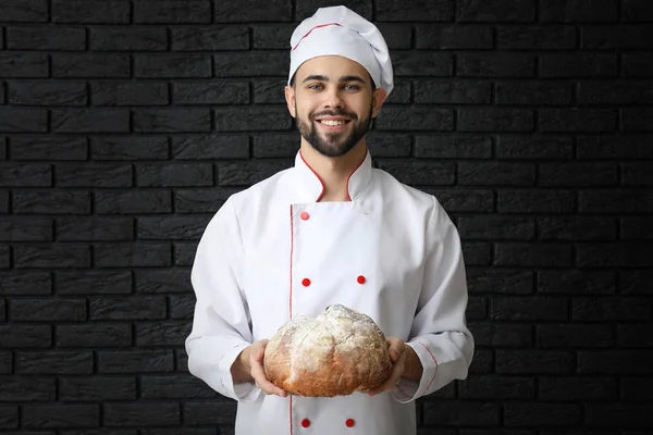 Шеф-повар со свежим хлебом на темном фоне — стоковое фото