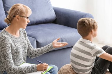 Ofiste küçük bir çocukla çalışan kadın psikolog