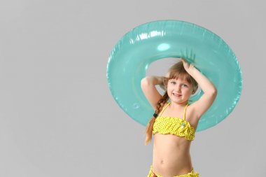 Gri arka planda şişme halka ile Sevimli küçük kız