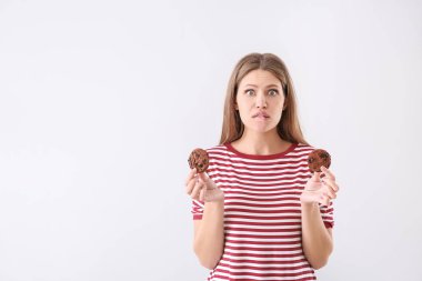 Hafif arka planda lezzetli kurabiye ile Duygusal genç kadın