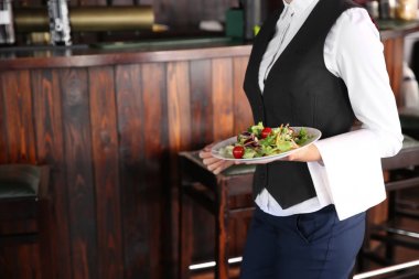 Genç kadın garson restoran salata ile