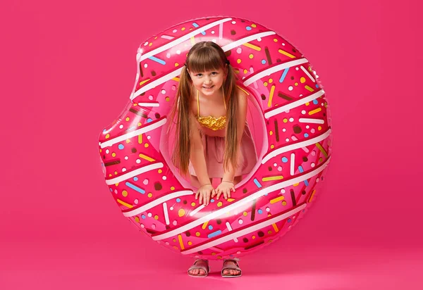 Söt liten flicka med uppblåsbar ring på färgbakgrund — Stockfoto