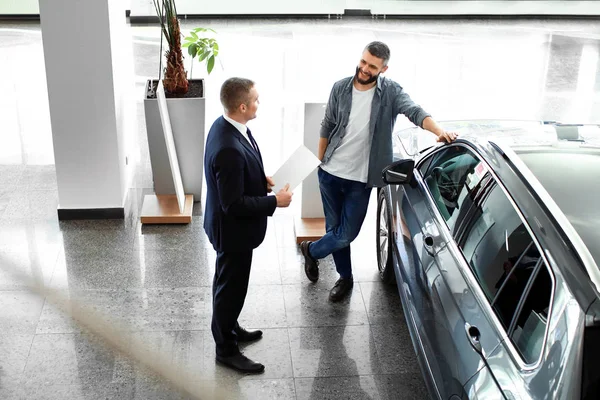 Man choosing new car in salon — Stock Photo, Image