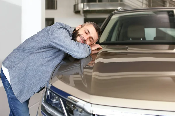 Człowiek wybiera nowy samochód w salonie — Zdjęcie stockowe