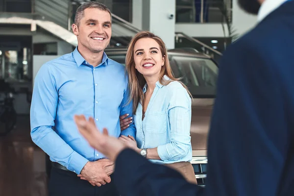 Couple choisissant une nouvelle voiture dans le salon — Photo