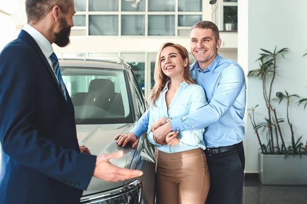 Couple choosing new car in salon — Stock Photo, Image