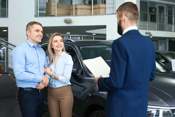 Pareja elegir un coche nuevo en el salón — Foto de Stock