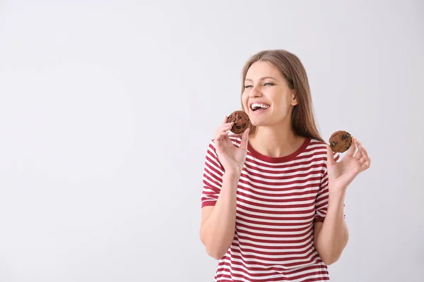 Beautiful young woman with tasty cookies on light background — Stock Photo, Image