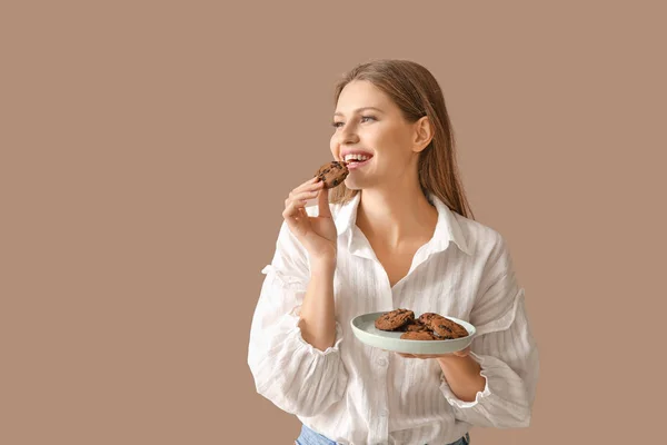 Beautiful young woman with tasty cookies on color background — Stock Photo, Image