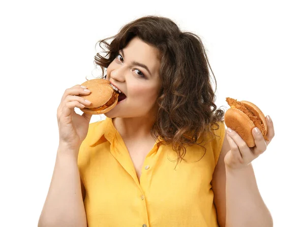 Mulher com excesso de peso com hambúrgueres no fundo branco — Fotografia de Stock