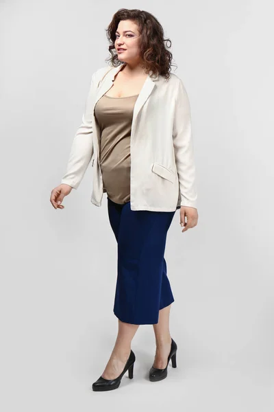 Stylish overweight woman on light background — Stock Photo, Image