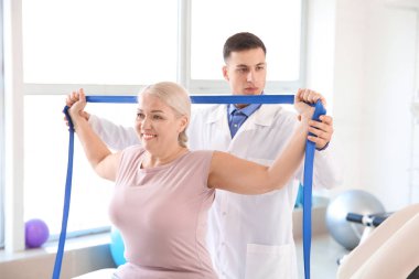 Rehabilitasyon merkezinde olgun hasta ile çalışan fizyoterapist