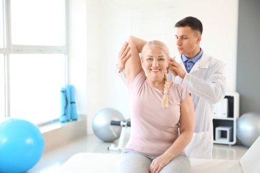 Rehabilitasyon merkezinde olgun hasta ile çalışan fizyoterapist