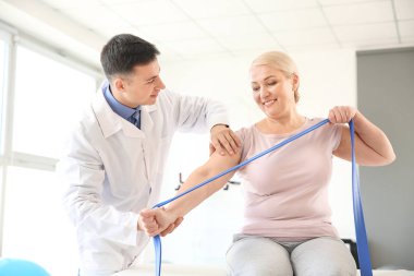 Rehabilitasyon merkezinde olgun hasta ile çalışan fizyoterapist