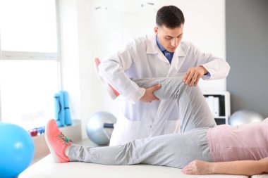 Rehabilitasyon merkezinde olgun hasta ile çalışan fizyoterapist