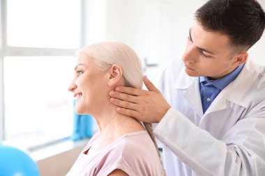 Rehabilitasyon merkezinde olgun hasta ile çalışan fizyoterapist
