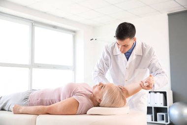 Rehabilitasyon merkezinde olgun hasta ile çalışan fizyoterapist