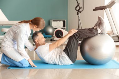 Rehabilitasyon merkezinde olgun hasta ile çalışan fizyoterapist