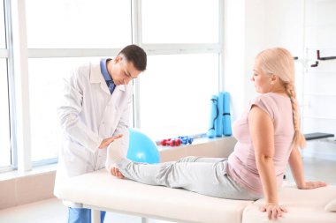 Rehabilitasyon merkezinde olgun hasta ile çalışan fizyoterapist